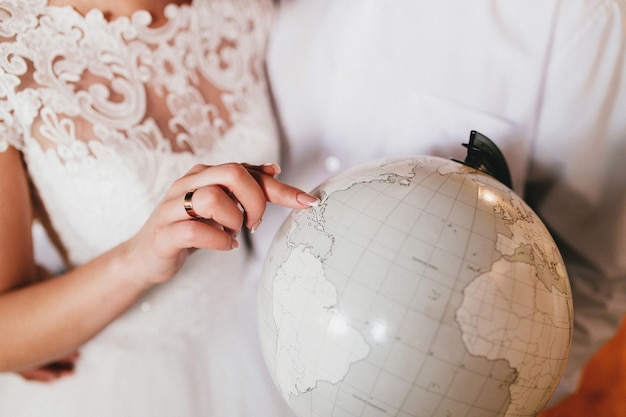 Bride is showing place on the globe. High quality photo