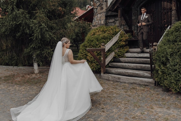 A bride is walking down the stairs in her wedding dress