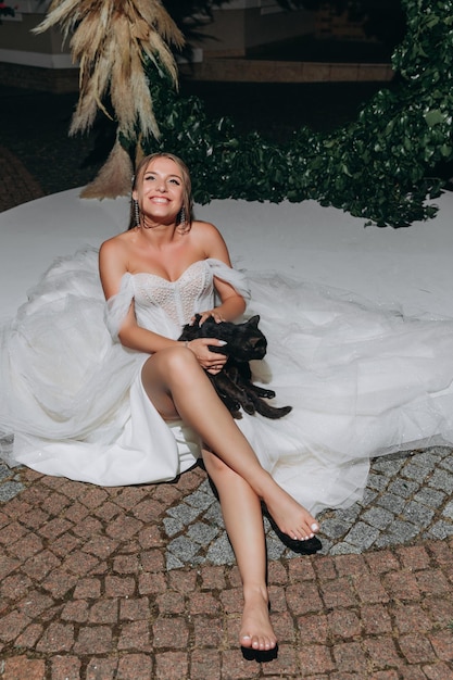 Bride lies near the wedding arch with black cat