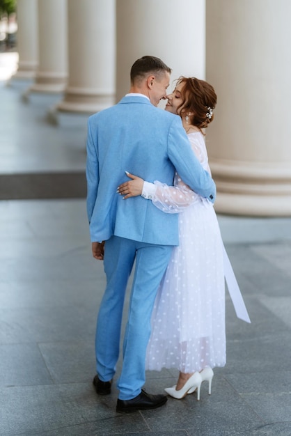 Невеста в легком свадебном платье к жениху в голубом костюме