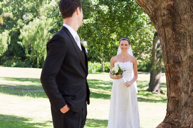 Bride looking at groom in garden