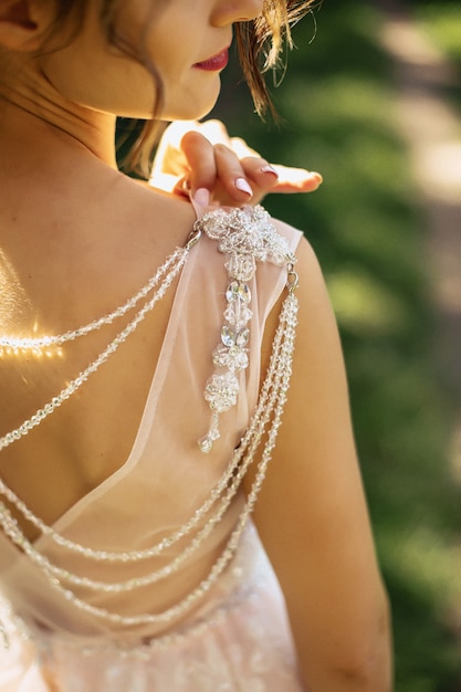 The bride looks at the shoulder with the beads