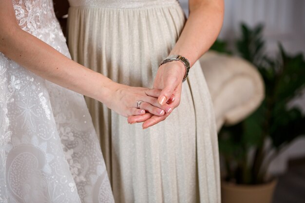 Bride and mother holding hands on the wedding day