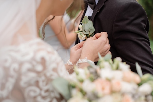 The bride pins on groom's boutonniere at the ceremony on wedding day