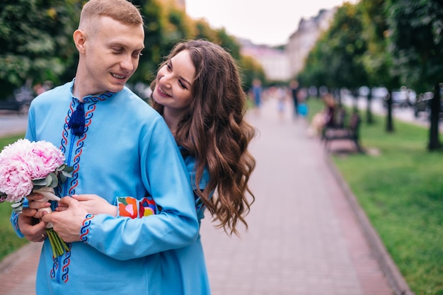 The bride playfully hugs her husband from behind looking at each other on a walk through the city