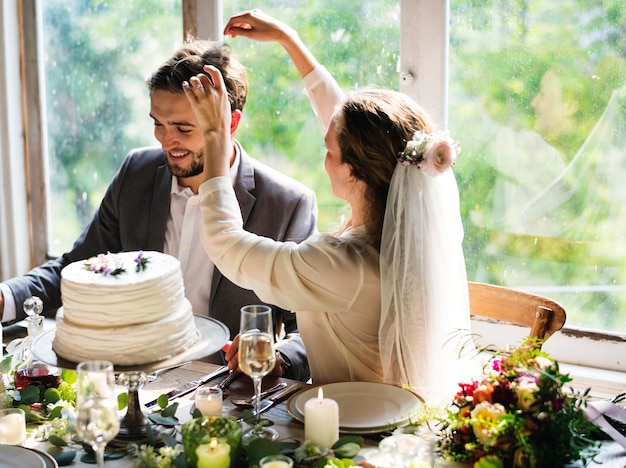 新郎の髪とレセプションテーブルで遊ぶ花嫁