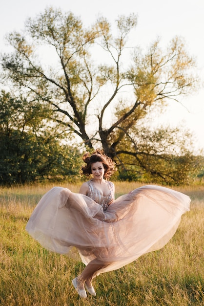 Bride posing in the field at sunset