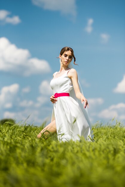 Bride posing on green field