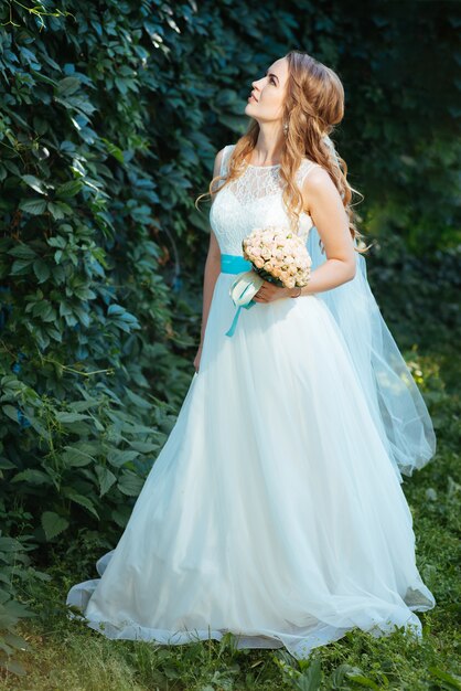 Bride posing for the photographer on the nature