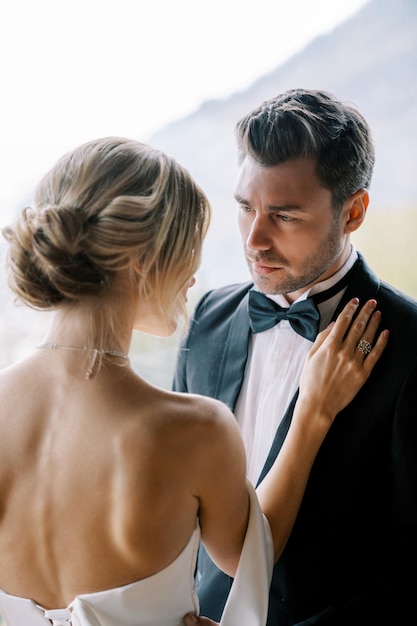 Foto la sposa mise la mano sulla spalla dello sposo guardandola da dietro