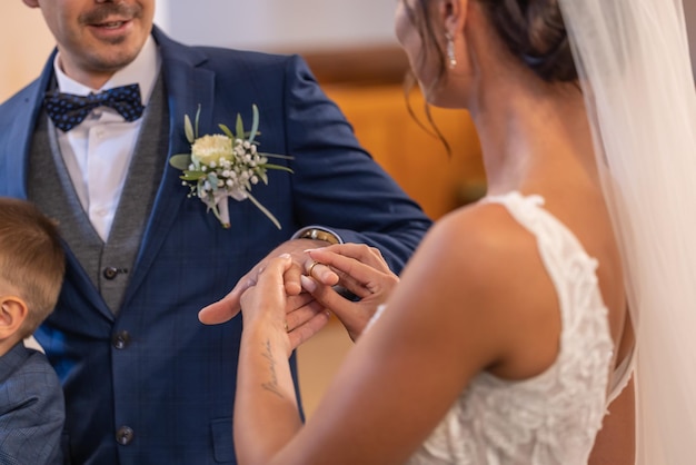 La sposa mette un anello al dito di uno sposo durante una cerimonia di matrimonio diventando marito e moglie