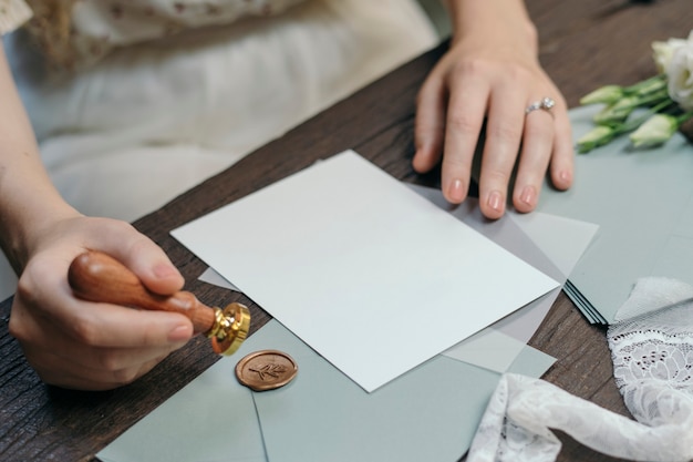 Bride putting a floral stamp on an envelope