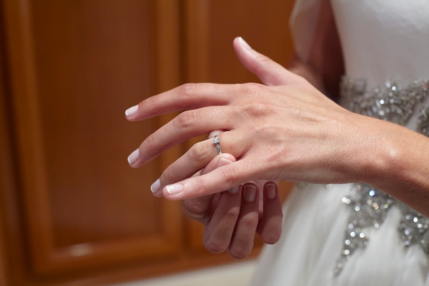 Bride putting on her wedding ring