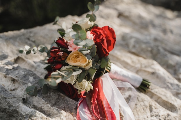 The bride's bouquet lies on a stone