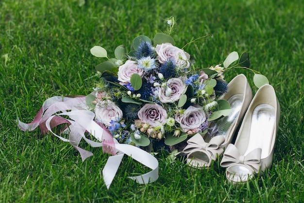 Bride's bouquet and shoes on the grass