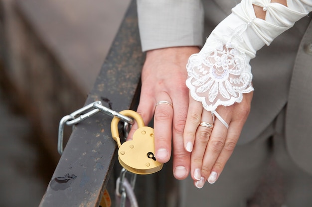 신부의 손과 하트 모양의 자물쇠를 닫은 신부의 손. 결혼식 관습. 고품질 사진