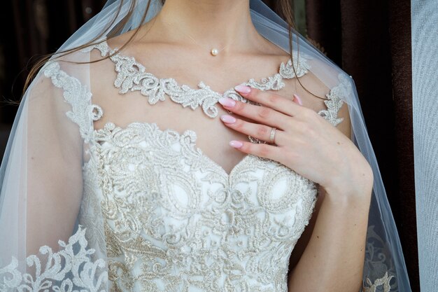 Bride's hands folded on a white wedding dress