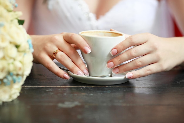 Bride's hands with a cup of coffee