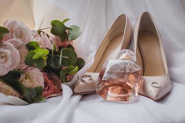 A Bride's shoes with a wedding bouquet and perfume on the veil. Wedding Concept