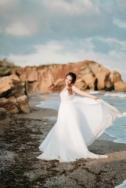 Bride on the shore of the black sea in the sunset light