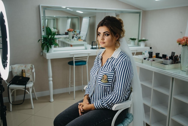 A bride sits in a dressing room in front of a mirror