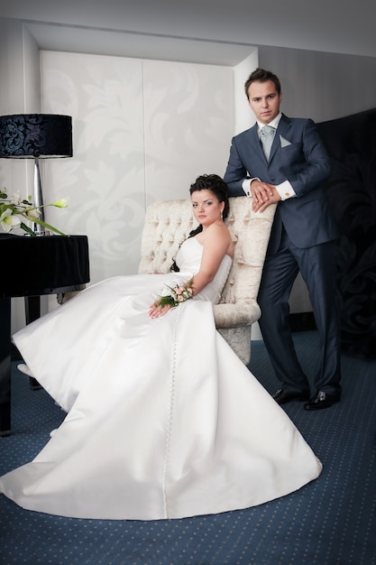 Bride sitting and Groom stand on a chai