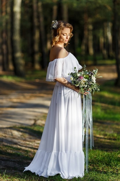 Bride standing and holding a wedding bouquet in hand