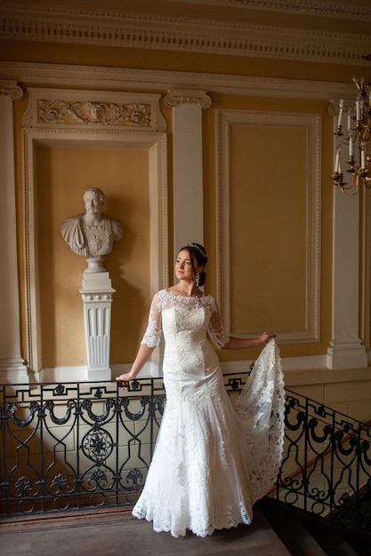 Bride standing on a staircase in a white dress