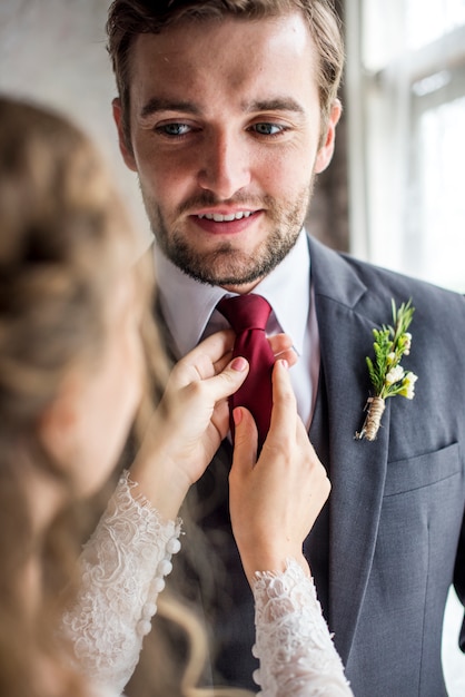 Foto la sposa si prende cura della cravatta dello sposo per il matrimonio