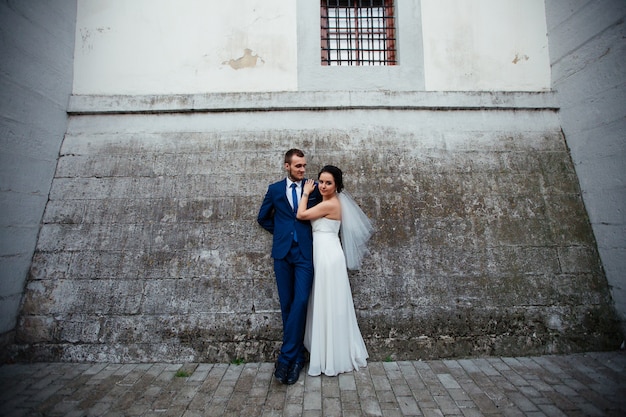 Bride tsiluyusvoho her lover on a background of gray wall