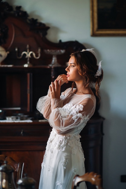 A bride in underwear and a white robe in the interior of a Villa in Italy