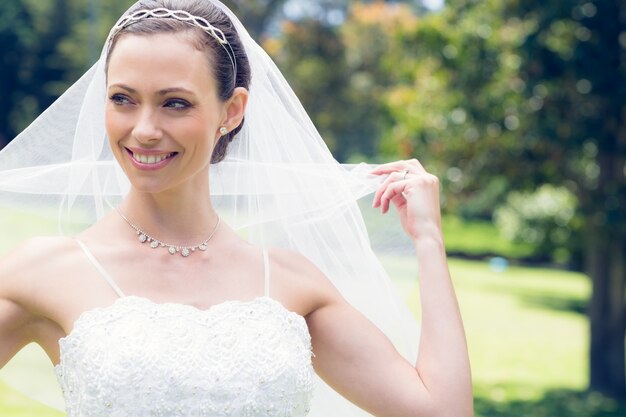 Bride unveiling self in garden