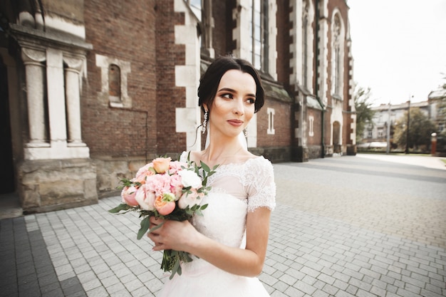 The bride on a walk near the wall of old gothic church