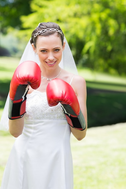 Bride wearing boxing gloves in garden