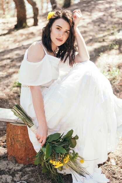 Bride wearing wedding dress taking a walk in the forest