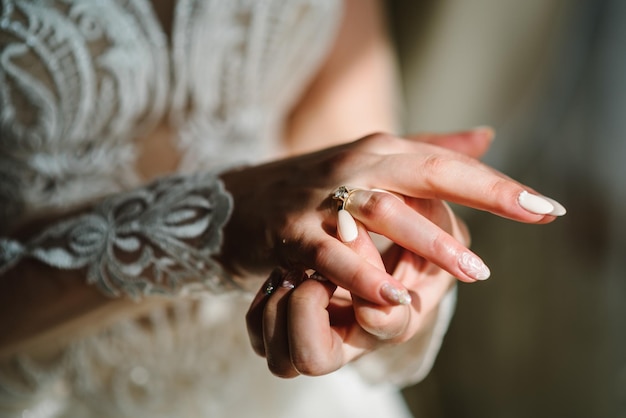 The bride wears or adjusts the diamond ring Close hands