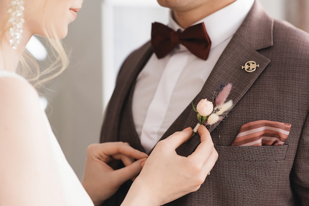 bride wears a flower boutonniere to the groom