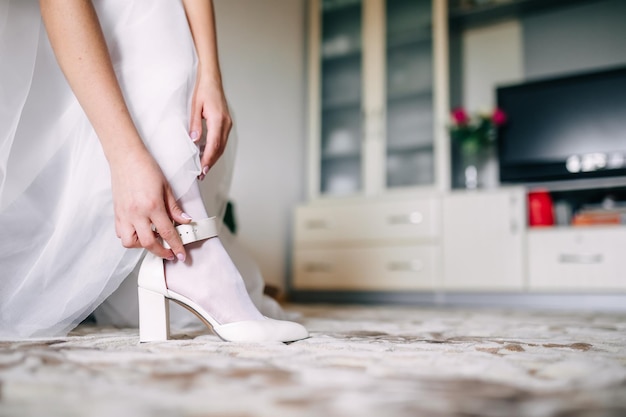 The bride wears highheeled shoes before the wedding ceremony Closeup detail of the bride