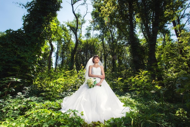 Bride on wedding in the amazing summer forest