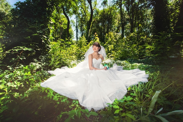 Bride on wedding in the amazing summer forest