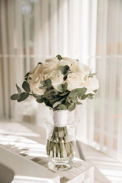 Foto la sposa bouquet da sposa di rose sotto la luce del sole nella stanza del mattino