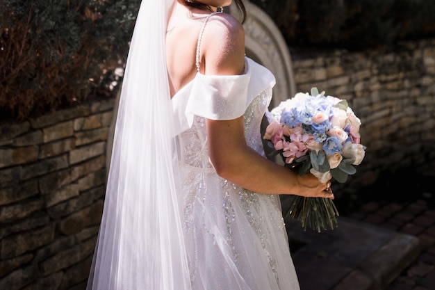 Bride in wedding dress and bouquet in the park