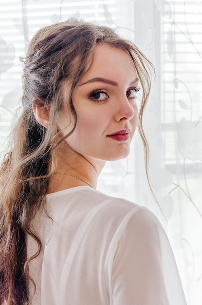 bride in a wedding dress by the window