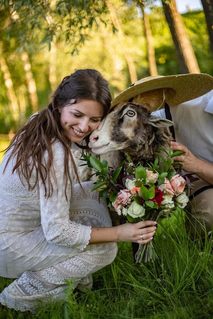 Bride in wedding dress hugs a ram rustic wedding