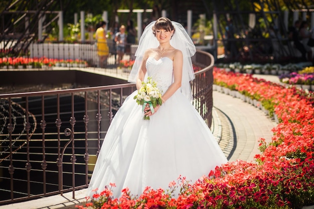 夏の近代的な公園での結婚式のフォトセッションの花嫁