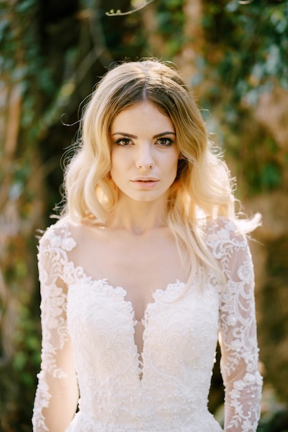 Bride in a white dress among greenery portrait