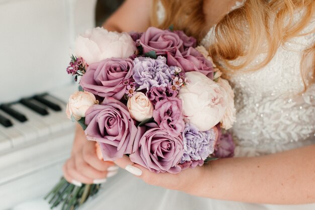 The bride in a white dress is holding a bridal bouquet. Wedding details