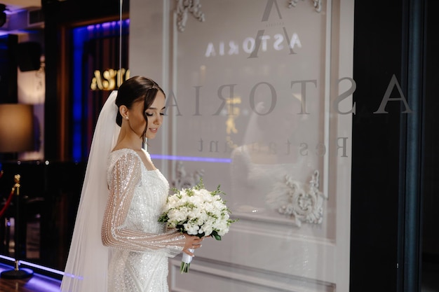 a bride in a white dress is standing in front of a window with the word escudo on it