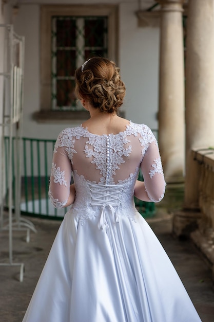 A bride in a white dress is walking towards a building
