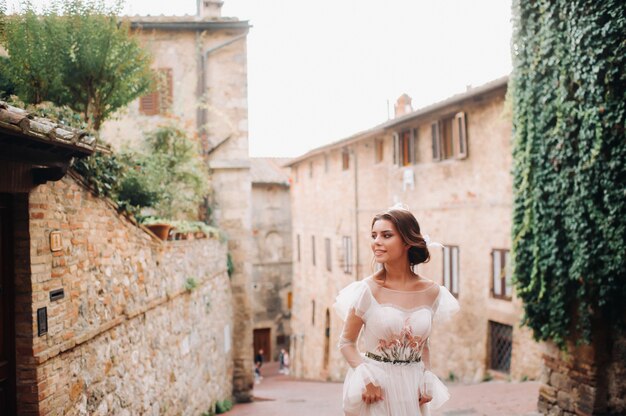 A bride in a white dress in the old town of San Gimignano